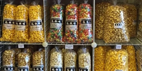 A shelf filled with lots of different types of popcorn.