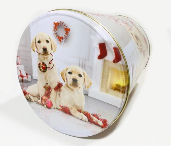 A round tin with two dogs sitting on top of it.