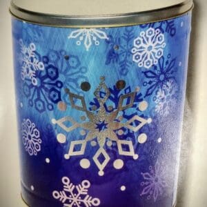 A blue and white jar with some silver snowflakes